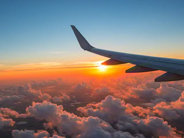View from plane window at sunset over clouds
