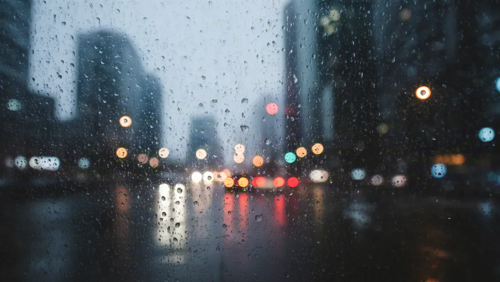 City lights glowing through rainy glass — cinematic night mood