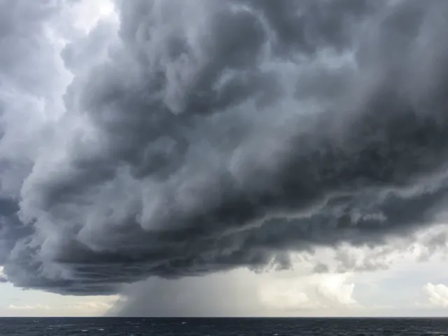 Heavy storm clouds hanging low over the sea with foamy waves.