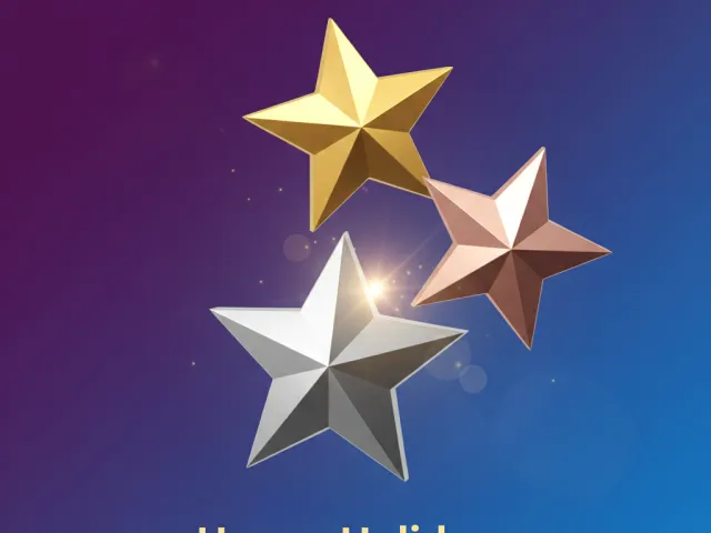 golden silver and rose star ornaments above happy holidays greeting on blue background