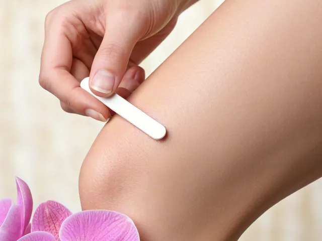 Woman doing leg waxing with orchid decoration
