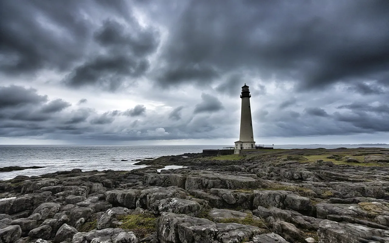 Storm clouds over lighthouse on rugged coast