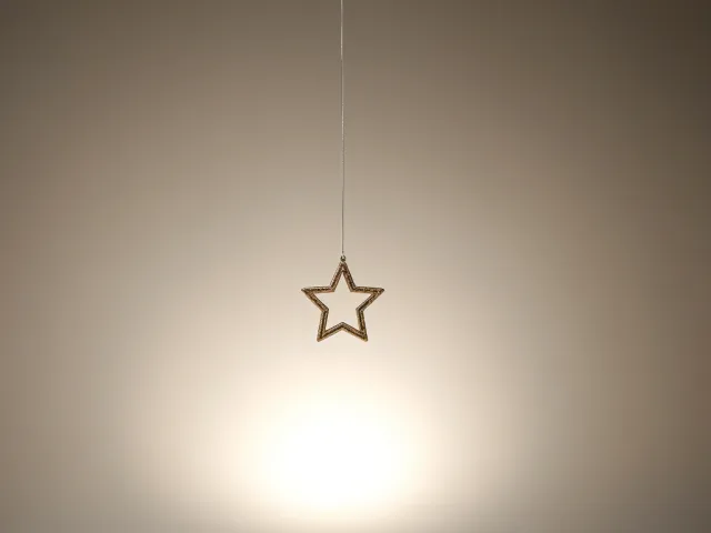Single star-shaped ornament hanging in soft warm lighting