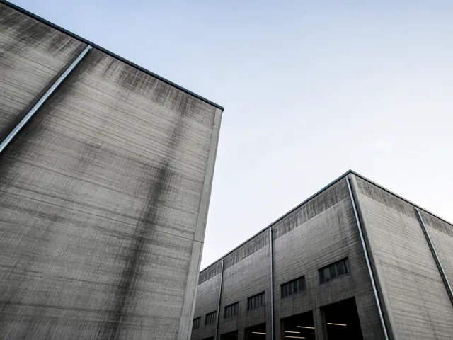 Modern industrial structure with gray textures and trees around.