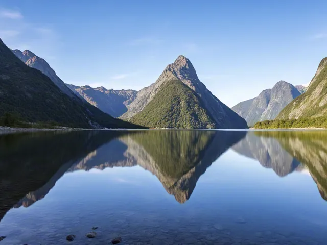 Clear mountain lake reflecting peaks and sky