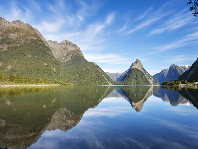 Clear lake reflecting mountains and blue sky