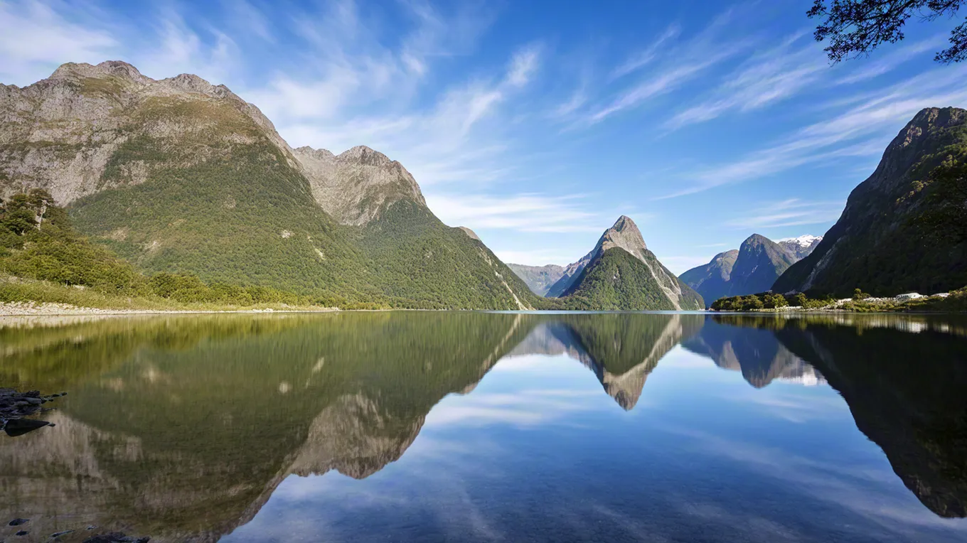 Clear lake reflecting mountains and blue sky