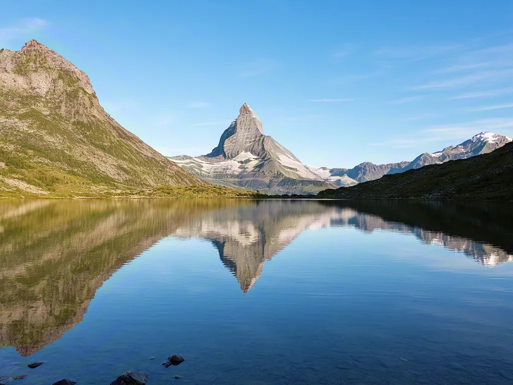 Mountain peak reflected in calm alpine lake