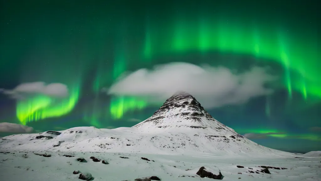 Northern lights over snowy mountain
