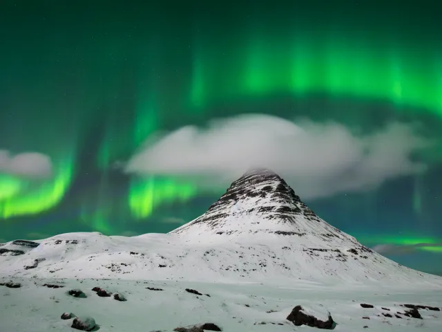 Aurora borealis above snow-covered peak