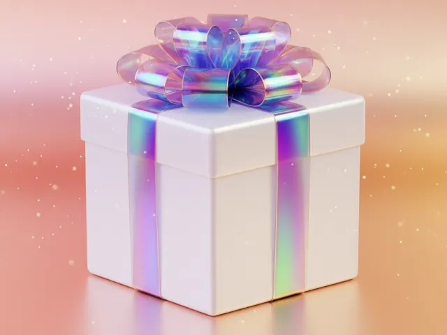 iridescent christmas gift box with shiny ribbon on soft pink background