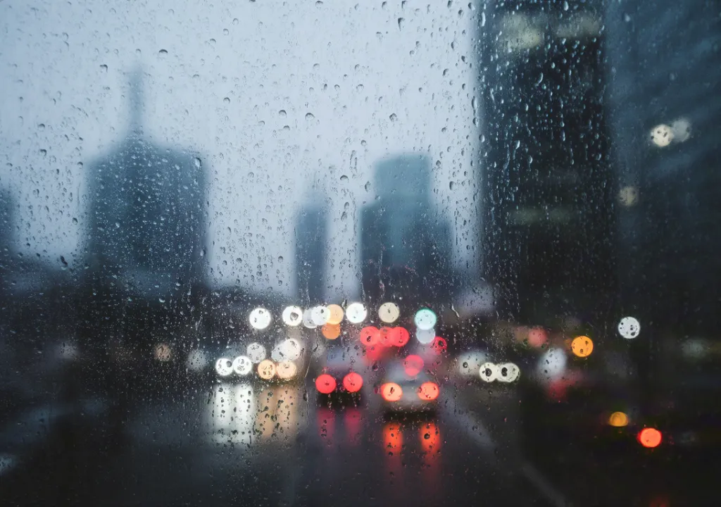 Rainy city street seen through wet window