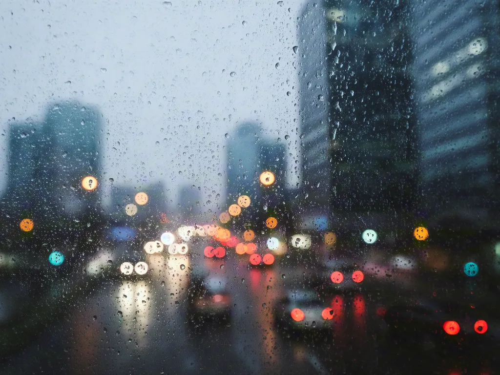Rainy city street with traffic lights and reflections