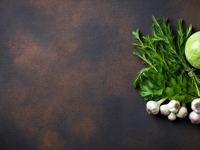 Fresh herbs and vegetables on rustic dark surface