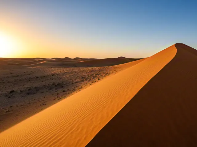 scenic golden sand dune under clear sky