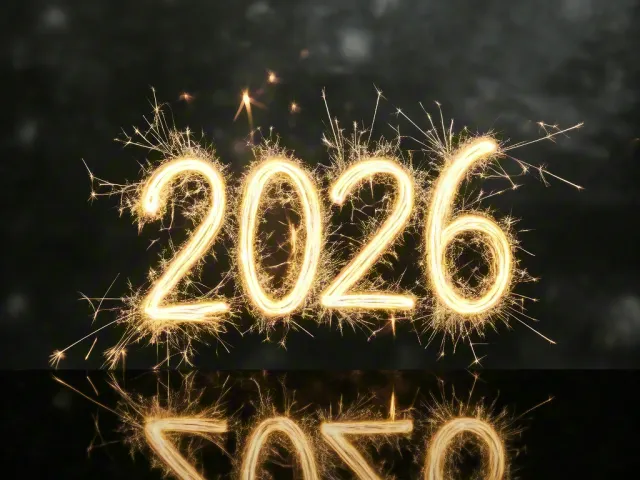 Glowing sparkler 2026 numbers reflecting on dark glossy surface