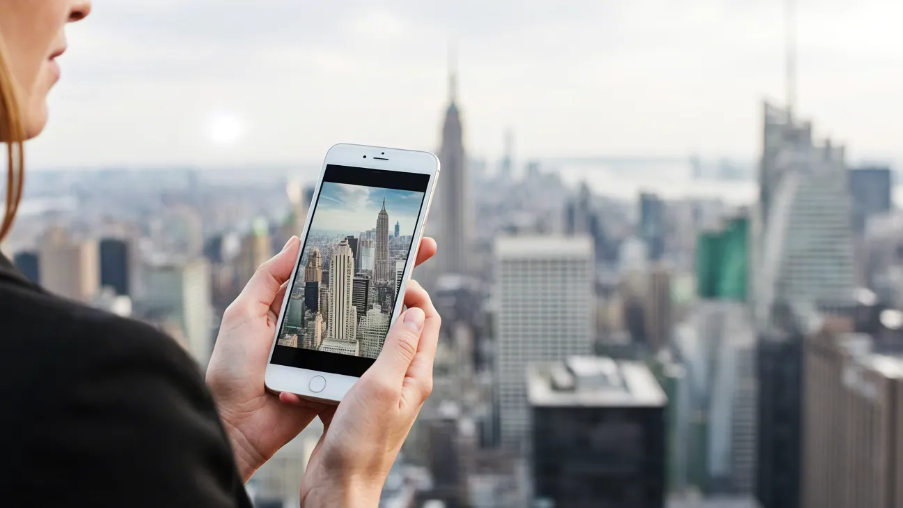 person photographing city skyline using a smartphone