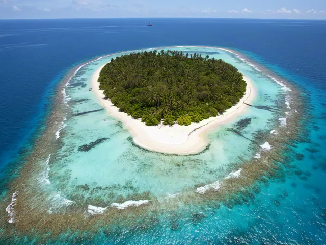 Small island surrounded by turquoise ocean