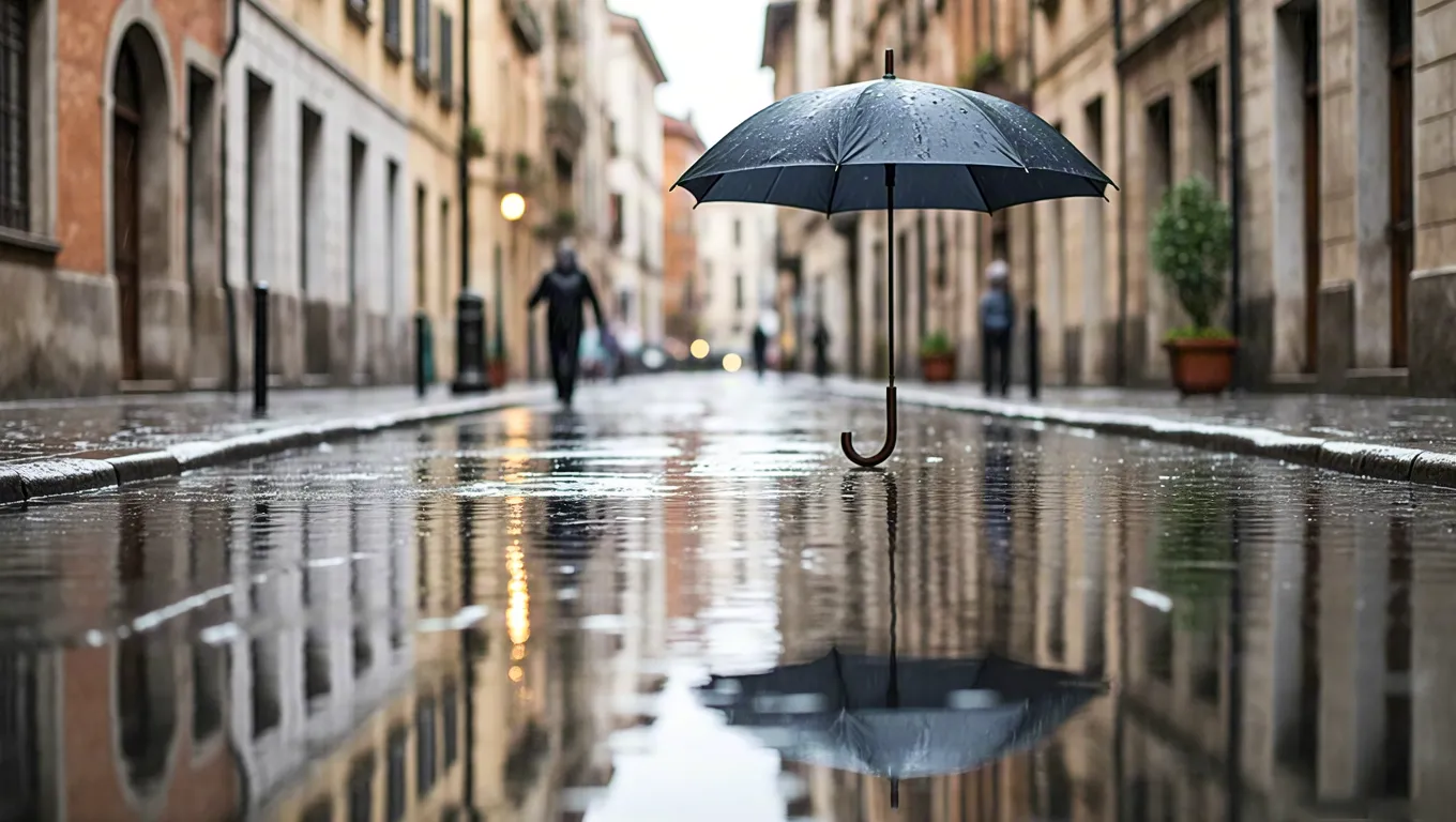Black umbrella suspended over a wet city street with reflections on the pavement during a rainy day
