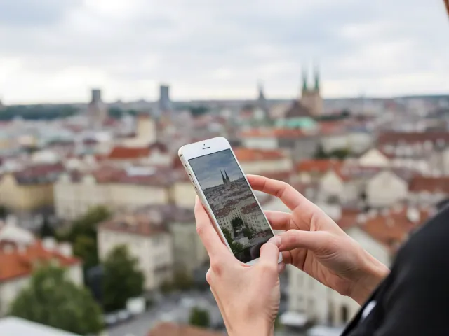 Person holding phone with city skyline in background